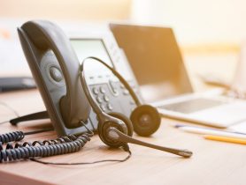 close up soft focus on headset with telephone devices at office desk for customer service support
