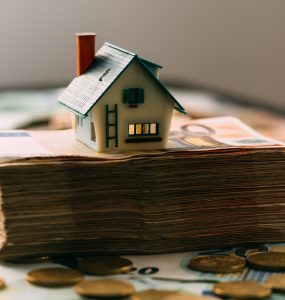 House model on cash stack closeup